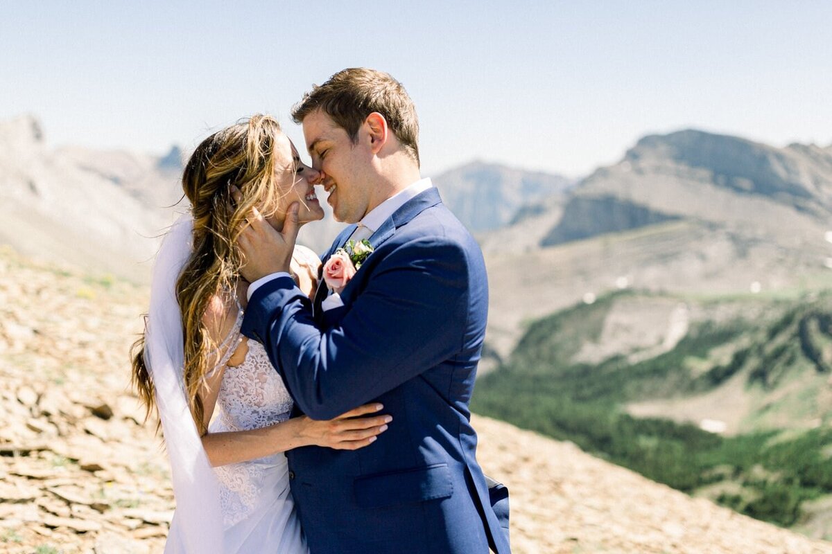 groom-kissing-his-bride-during-their-helicopter-mountain-adventure