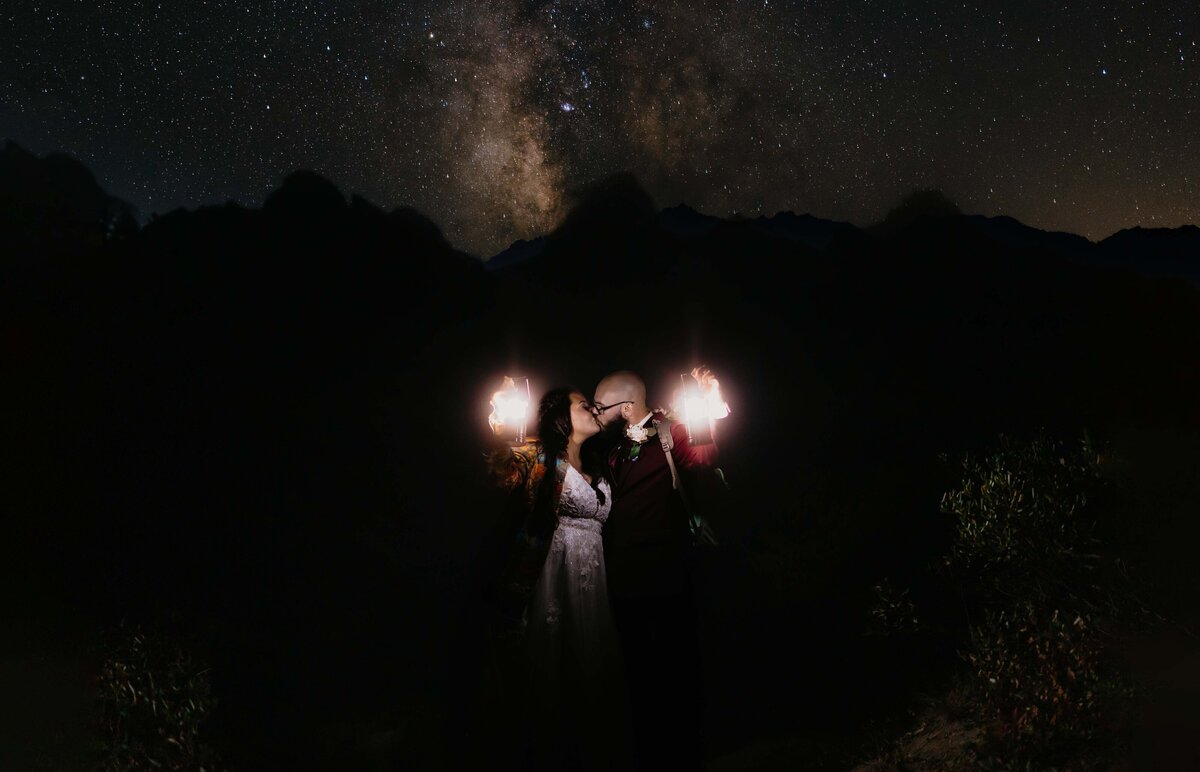 A couple holding lanterns beneath Grand Teton at Taggart Lake in Grand Teton National Park
