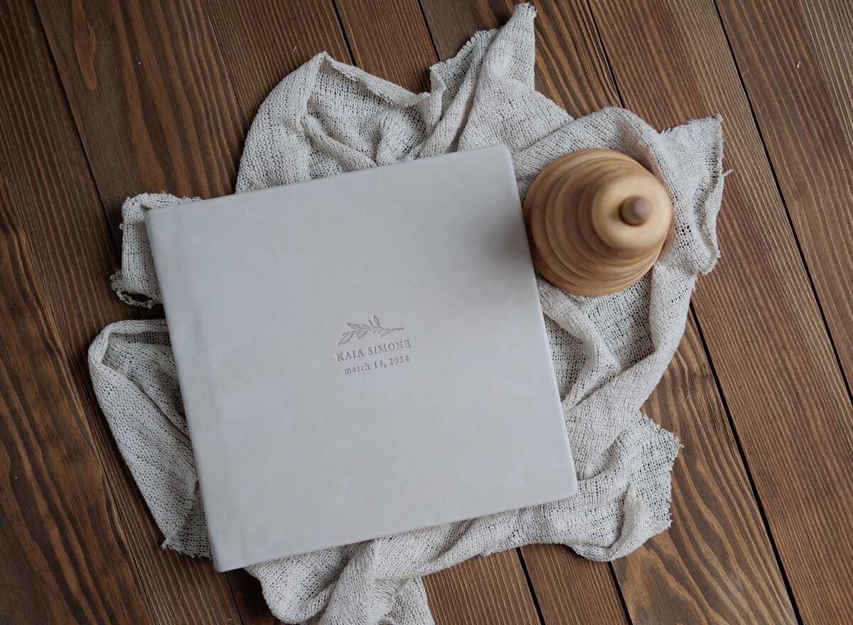 Gorgeous blue linen baby album , embosed with the baby's name sit beside and organic wood stacking toy