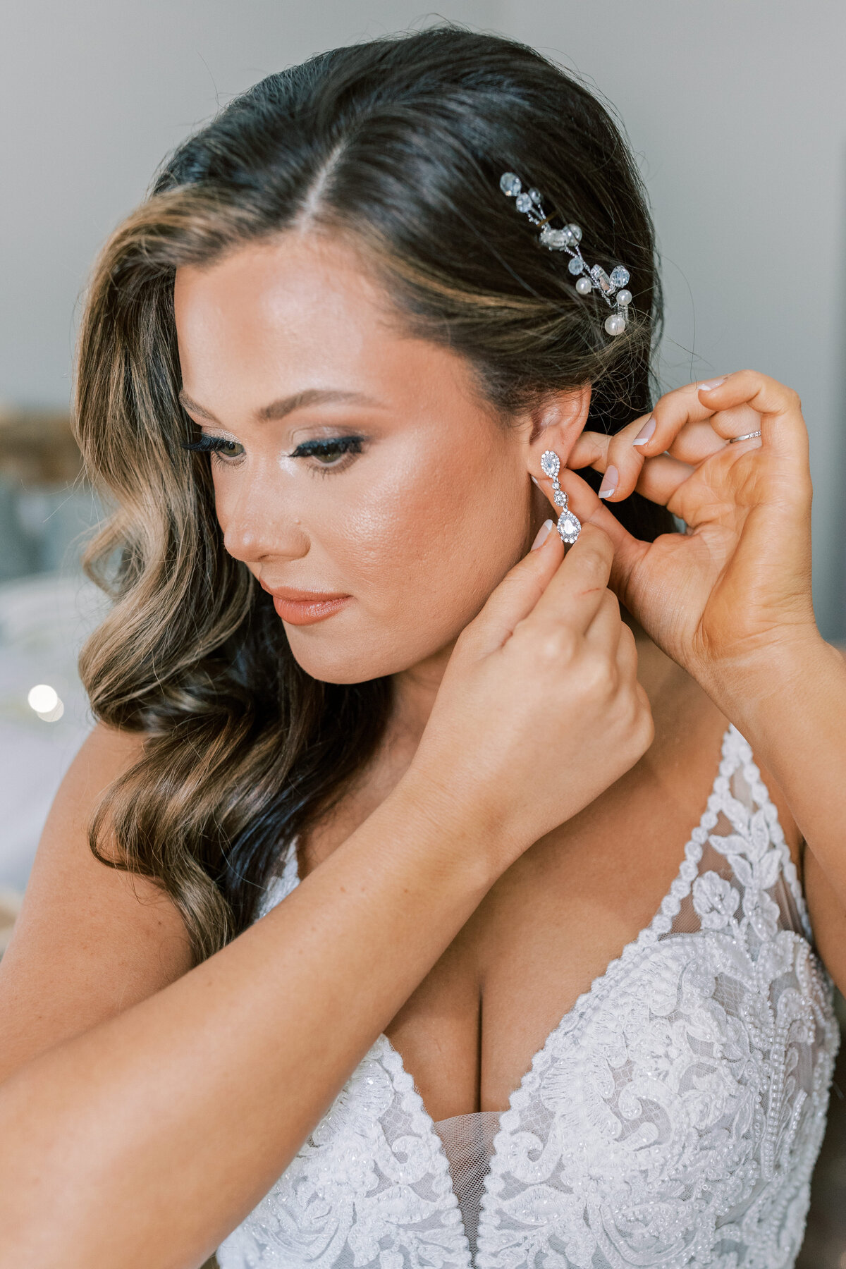 A gorgeous bride puts her earring in.
