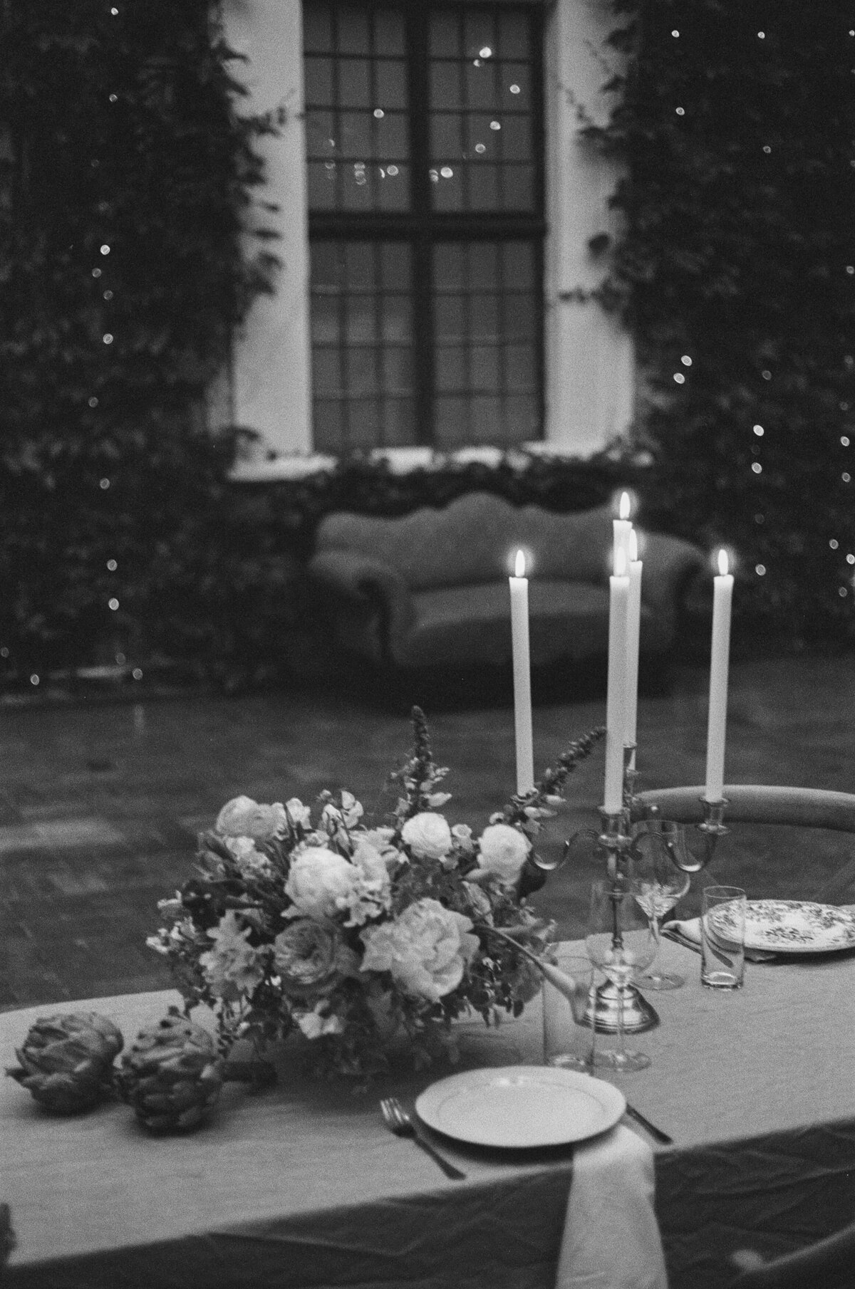 Cérémonie de mariage dans une ambiance moody, avec une table romantique décorée de fleurs.