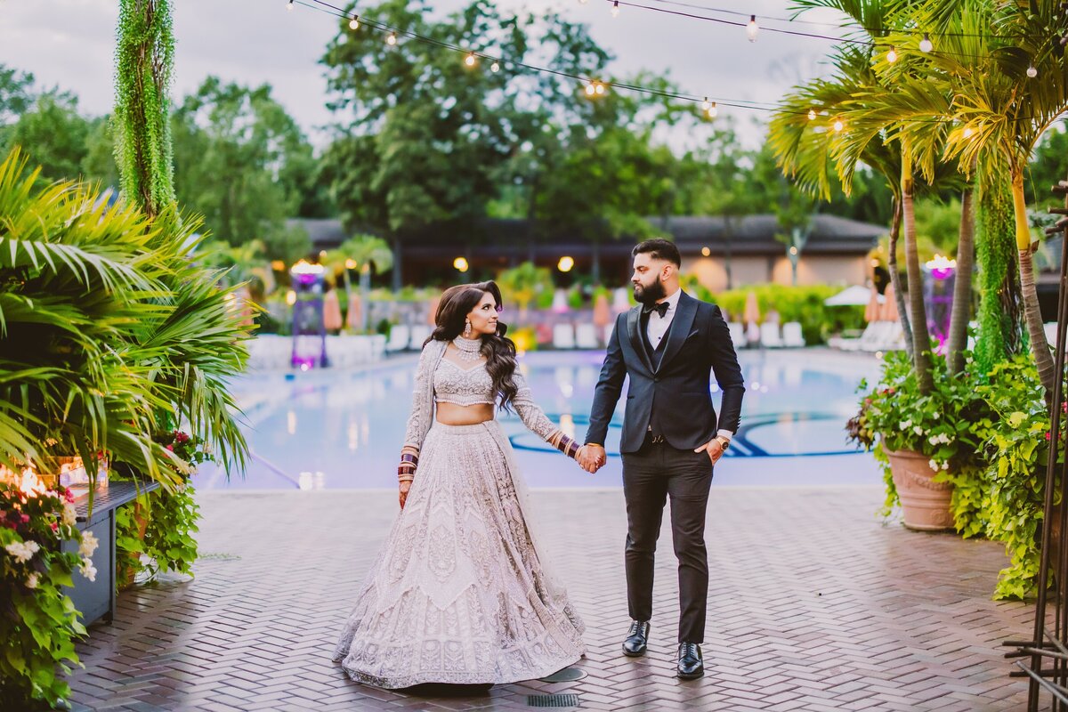 Indian sikh bride and groom wearing silver lehnga walking outside before the wedding reception at crest hollow country club ny