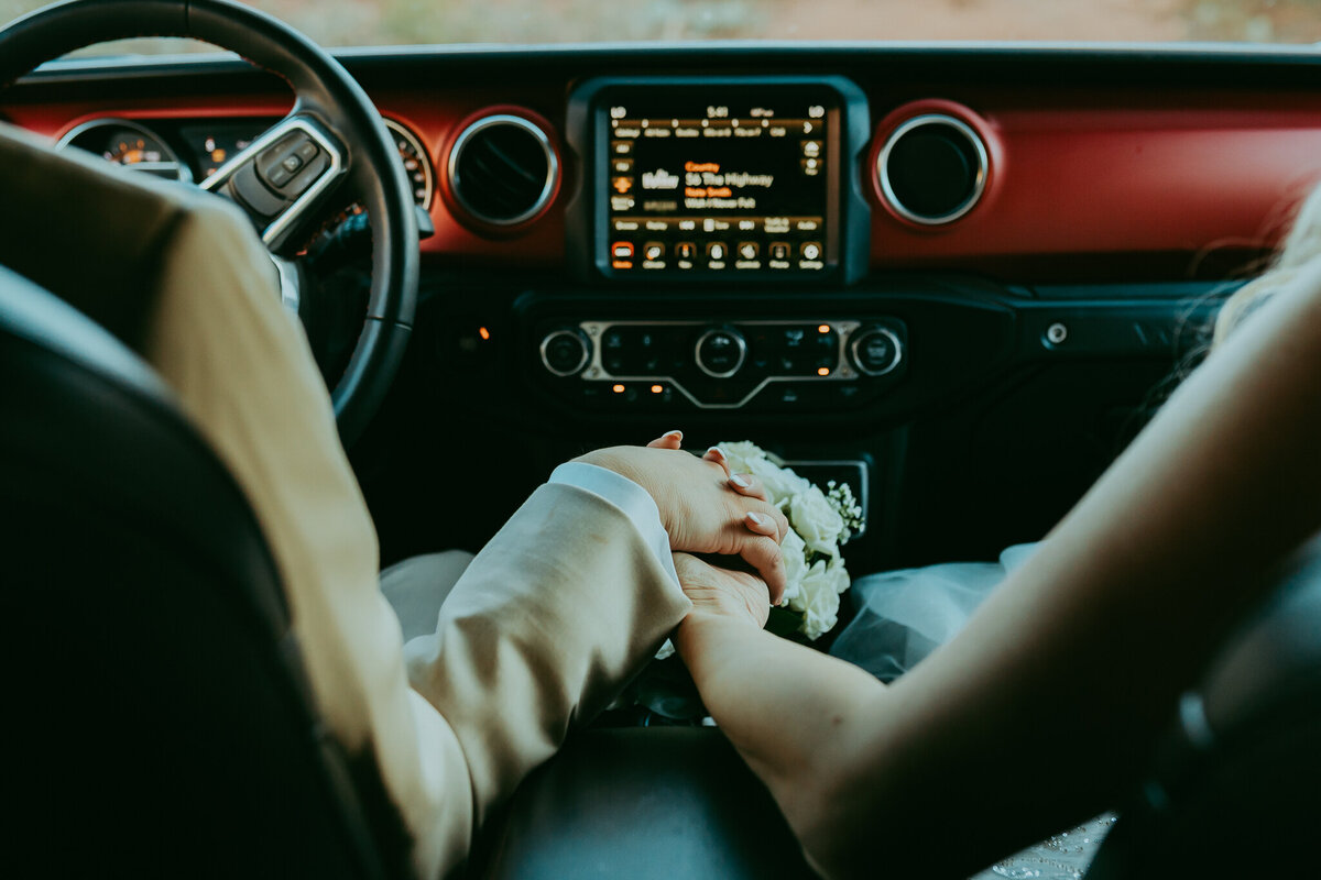 couple holding hands in a jeep