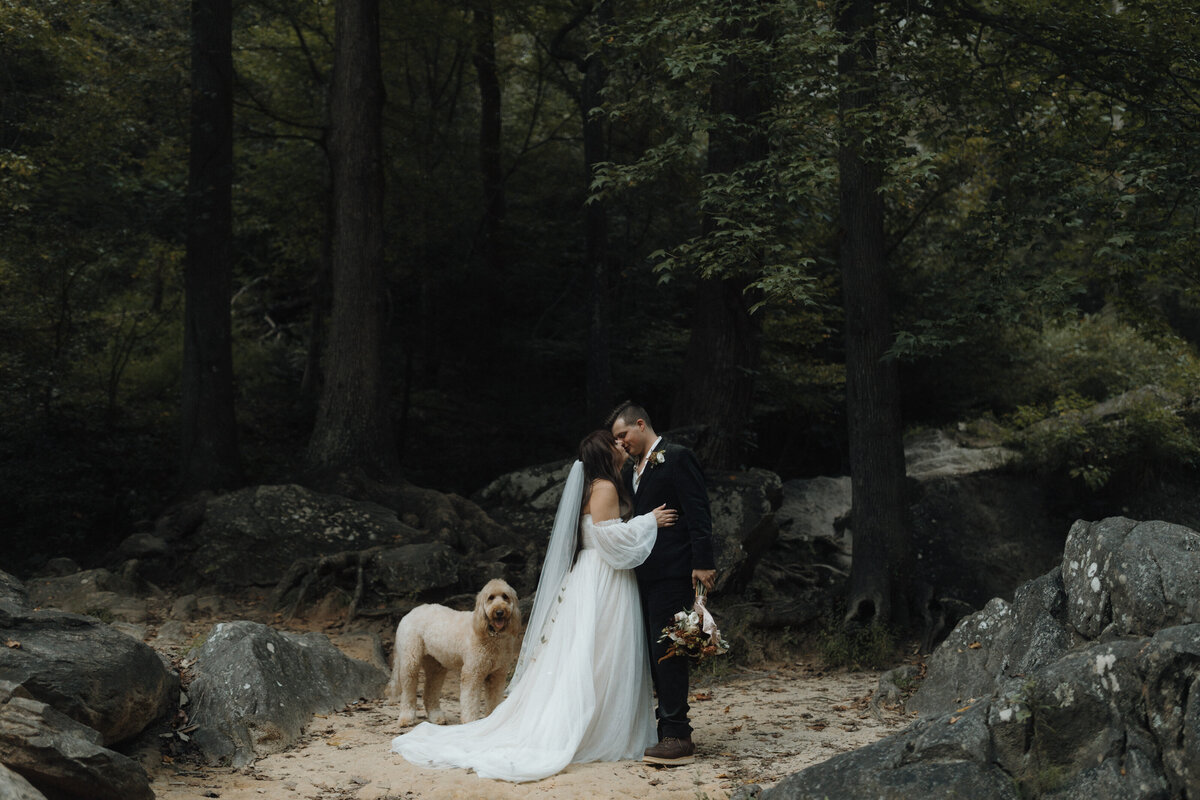 bride and groom holding lanterns walking in rain on a road  after elopement on mountain