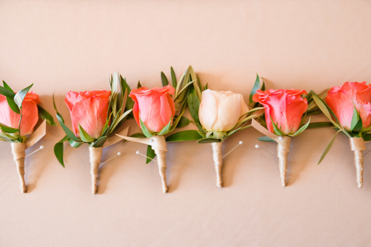 groomsmen boutoneirs of coral roses