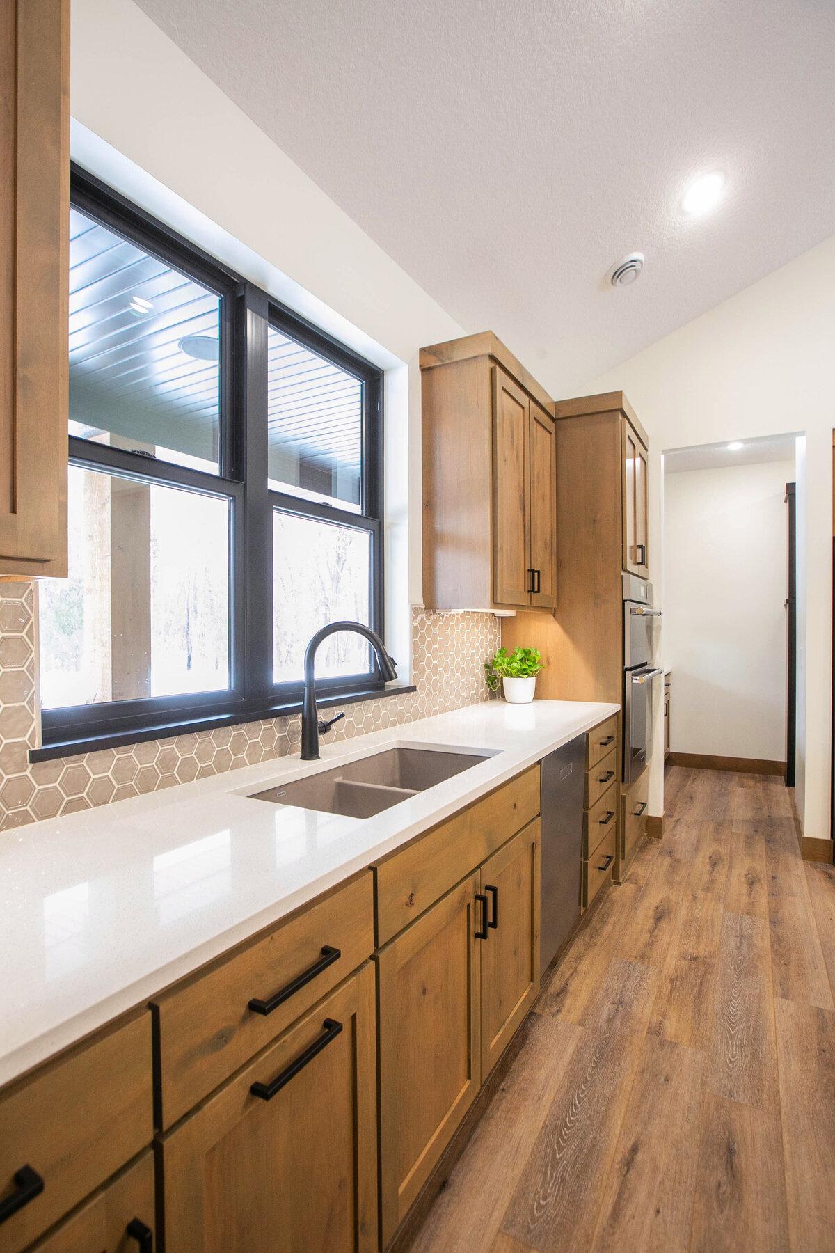 Open kitchen with dark cabinets, large island, and quartz countertops in an Elk River custom home