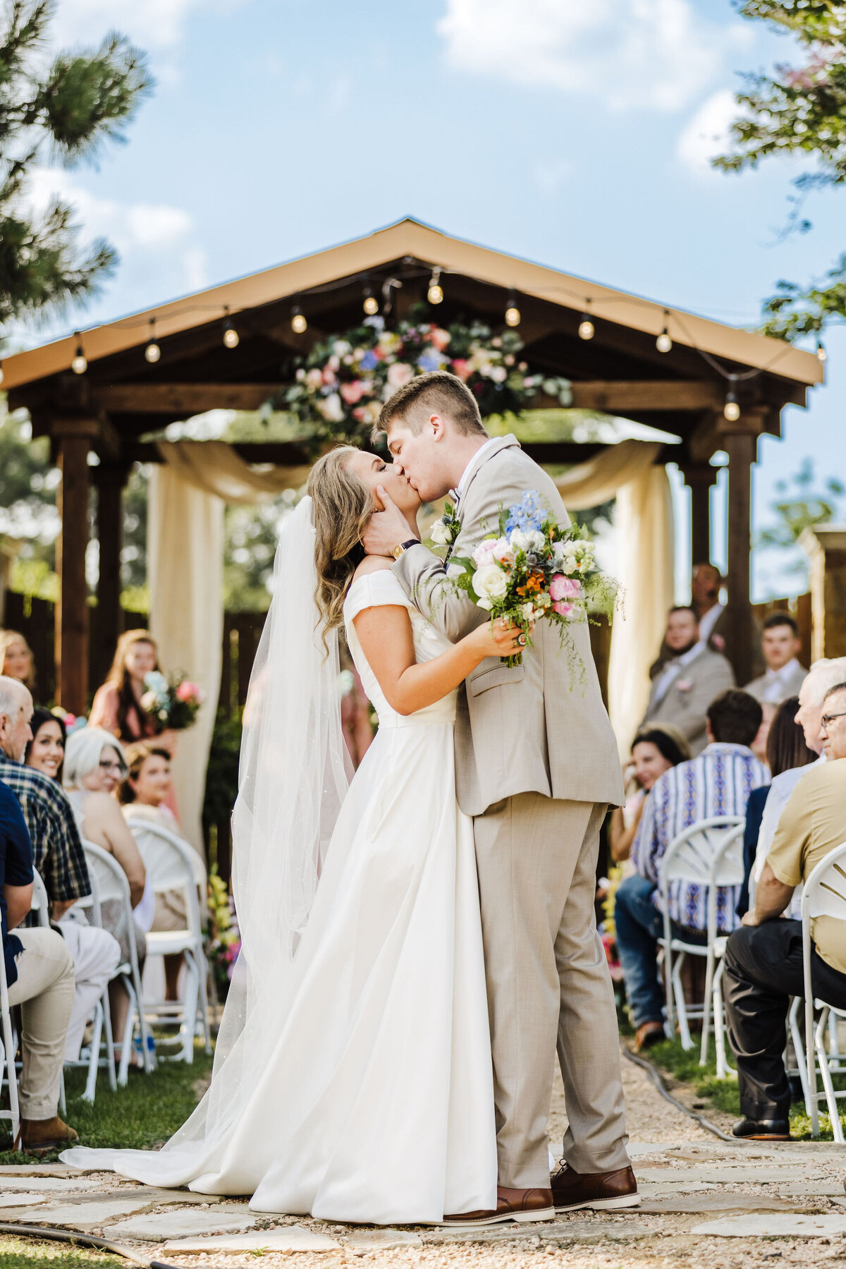 Bride and groom kissing at end of isle at Longview, Texas wedding venue