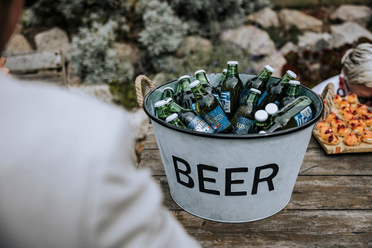 A bucket full of beer sitting on top of a wooden table
