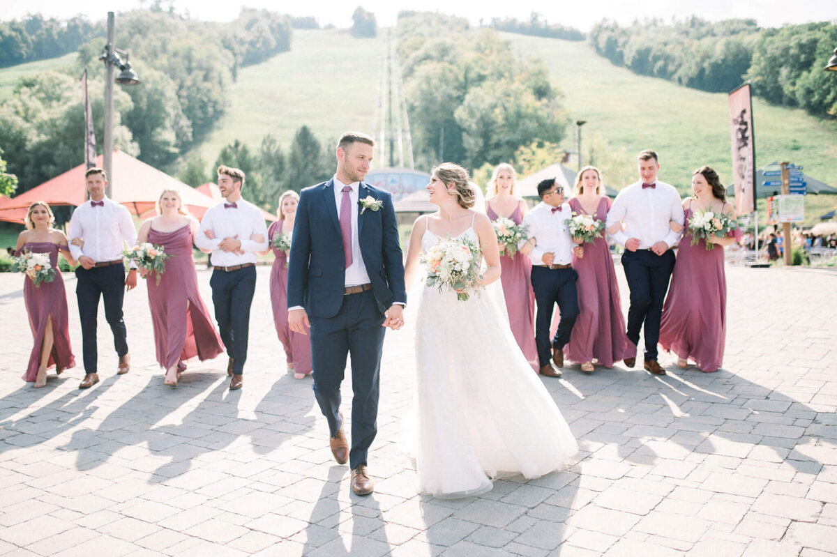 Bride and Groom walking ahead of wedding party captured by Toronto wedding photography