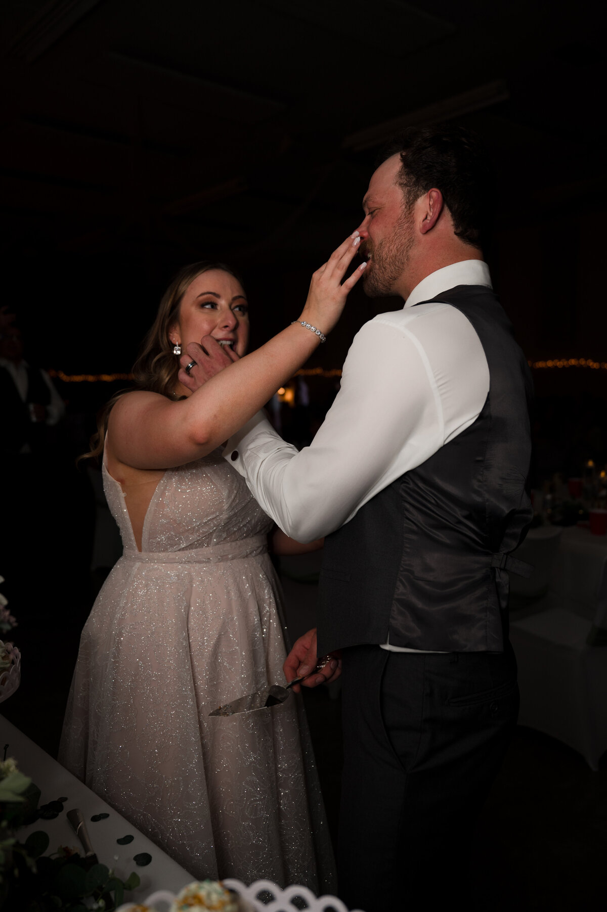 bride and groom feeding each other cake on wedding day