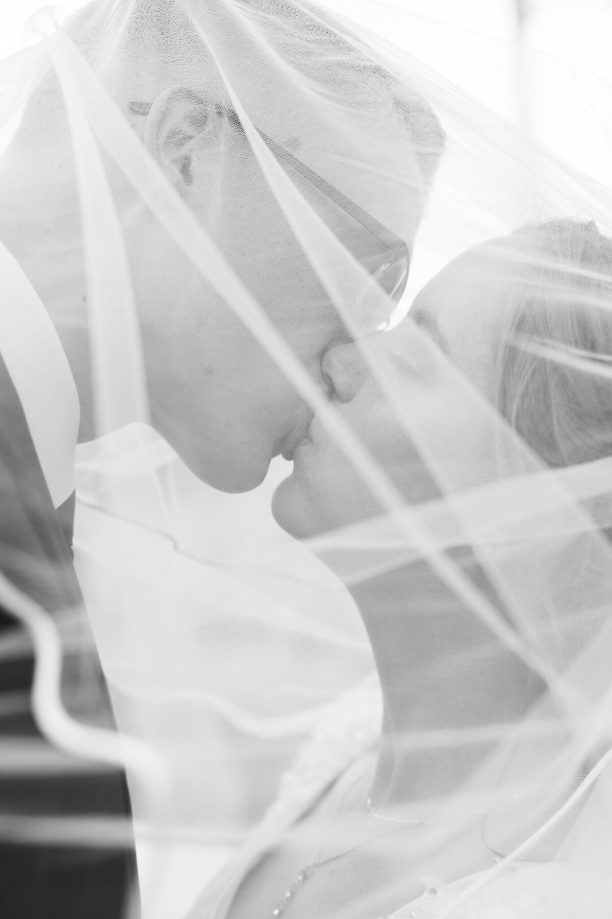 Bride and groom sharing a kiss under the veil on their wedding day talen by spokane wedding photographer