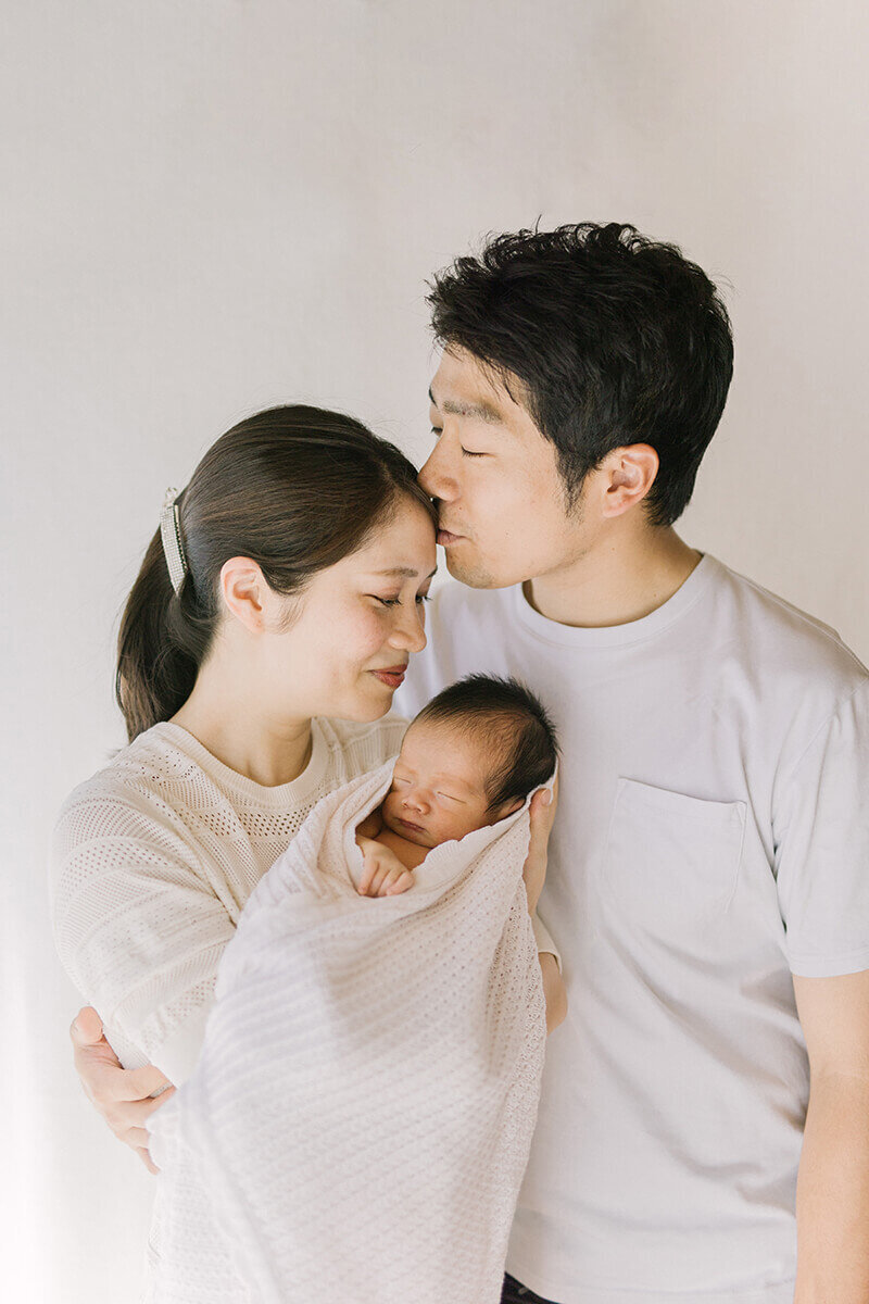 パパとママと赤ちゃん3人のホワイトコーデでオシャレなニューボーンフォト