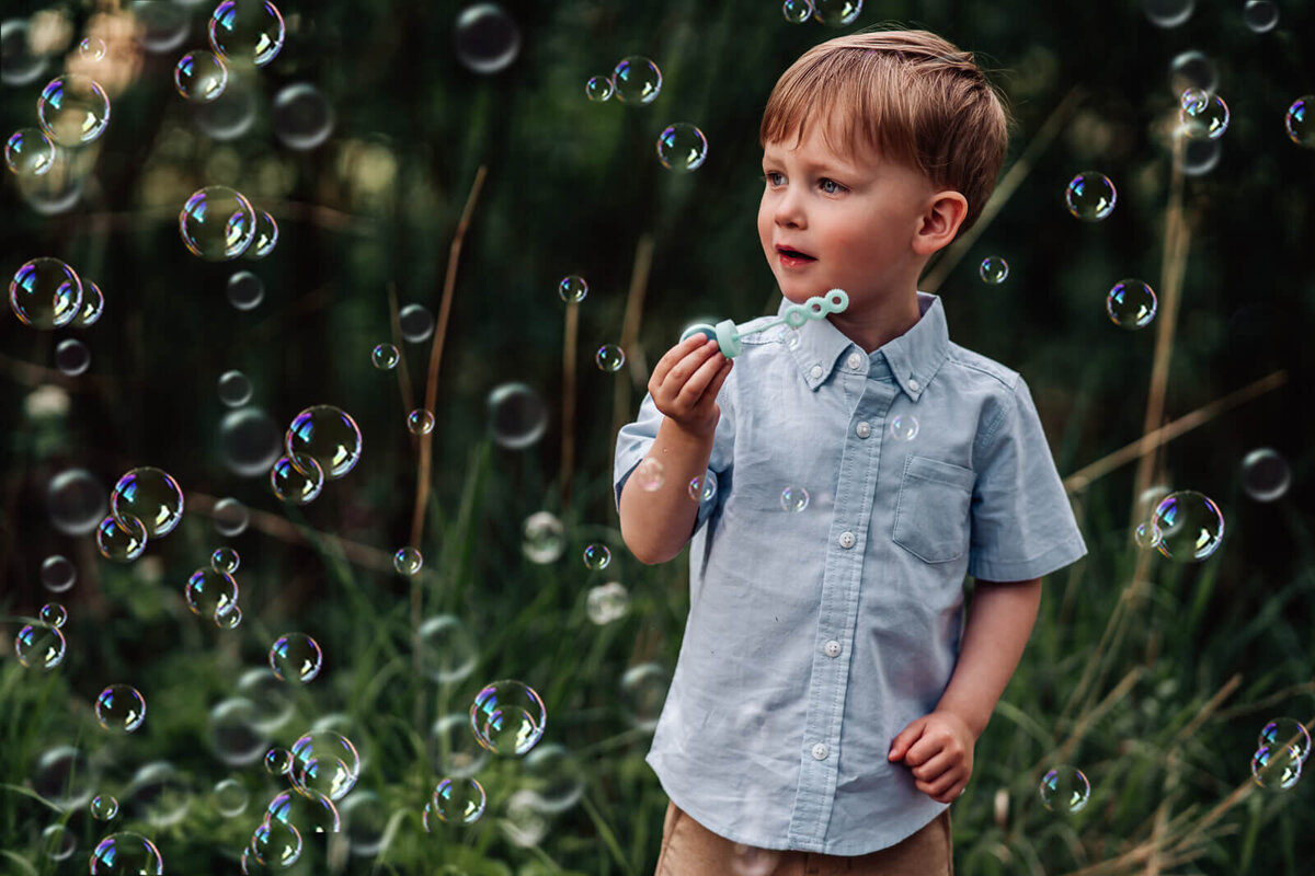 A young boy gazes in awe at the bubbles he just blew near Lake Harriet in Minneapolis, MN.