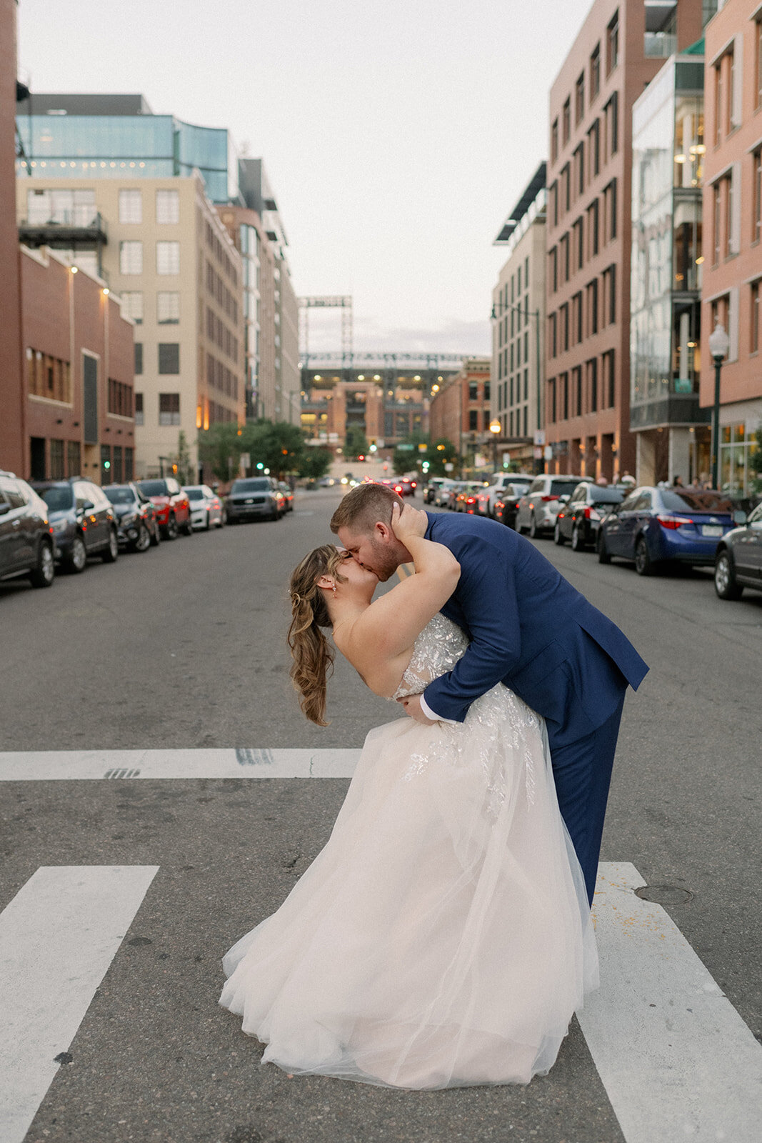 Bride and groom  kiss in the streets of downtown Denver on their wedding day.