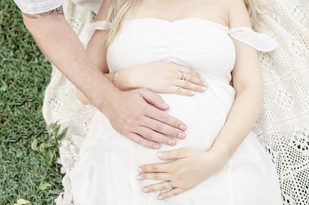 Hands lay on a pregnant woman's stomach