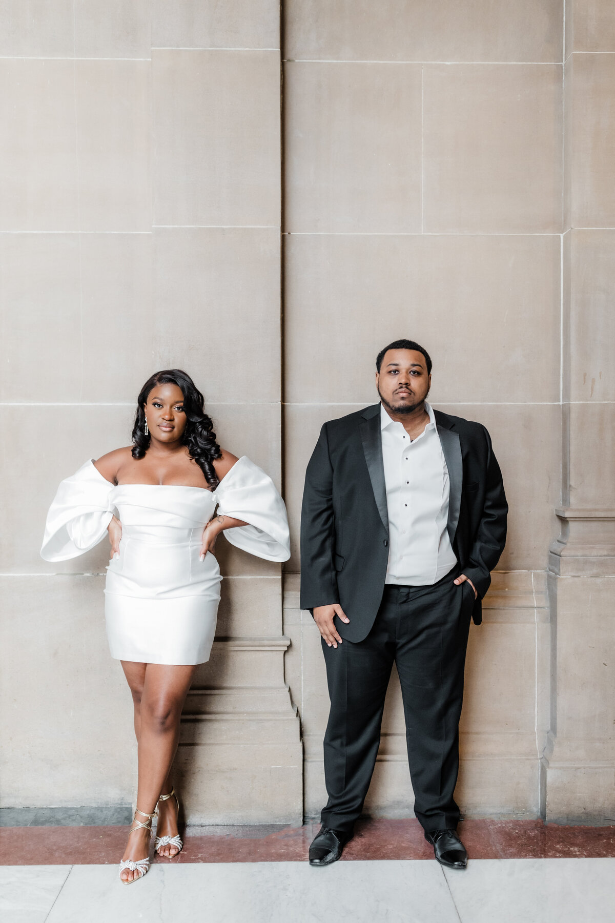 Couple dressed stylishly for their engagement session, standing confidently in downtown South Bend.