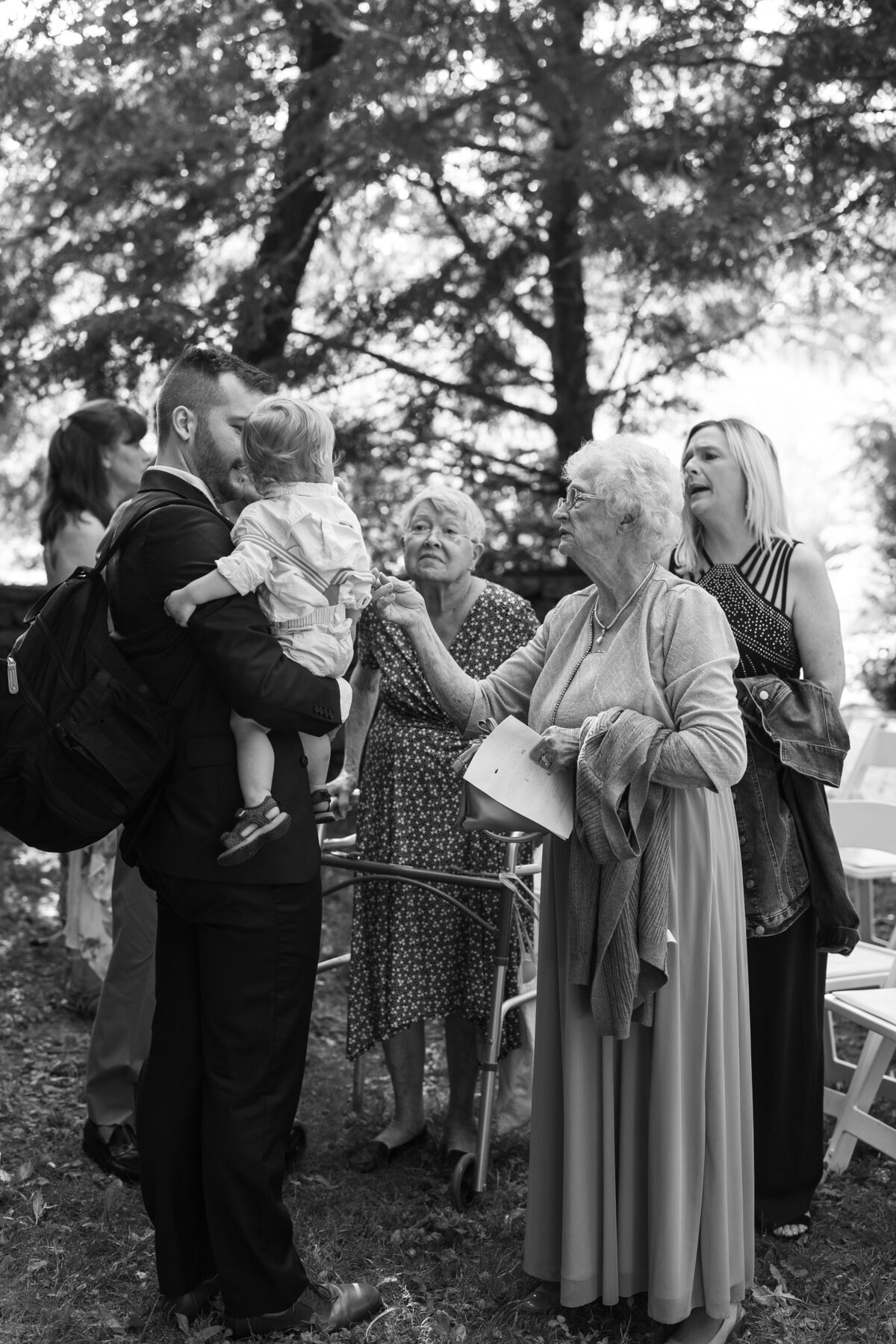 A grandmother reaches out to touch her little grandchild.