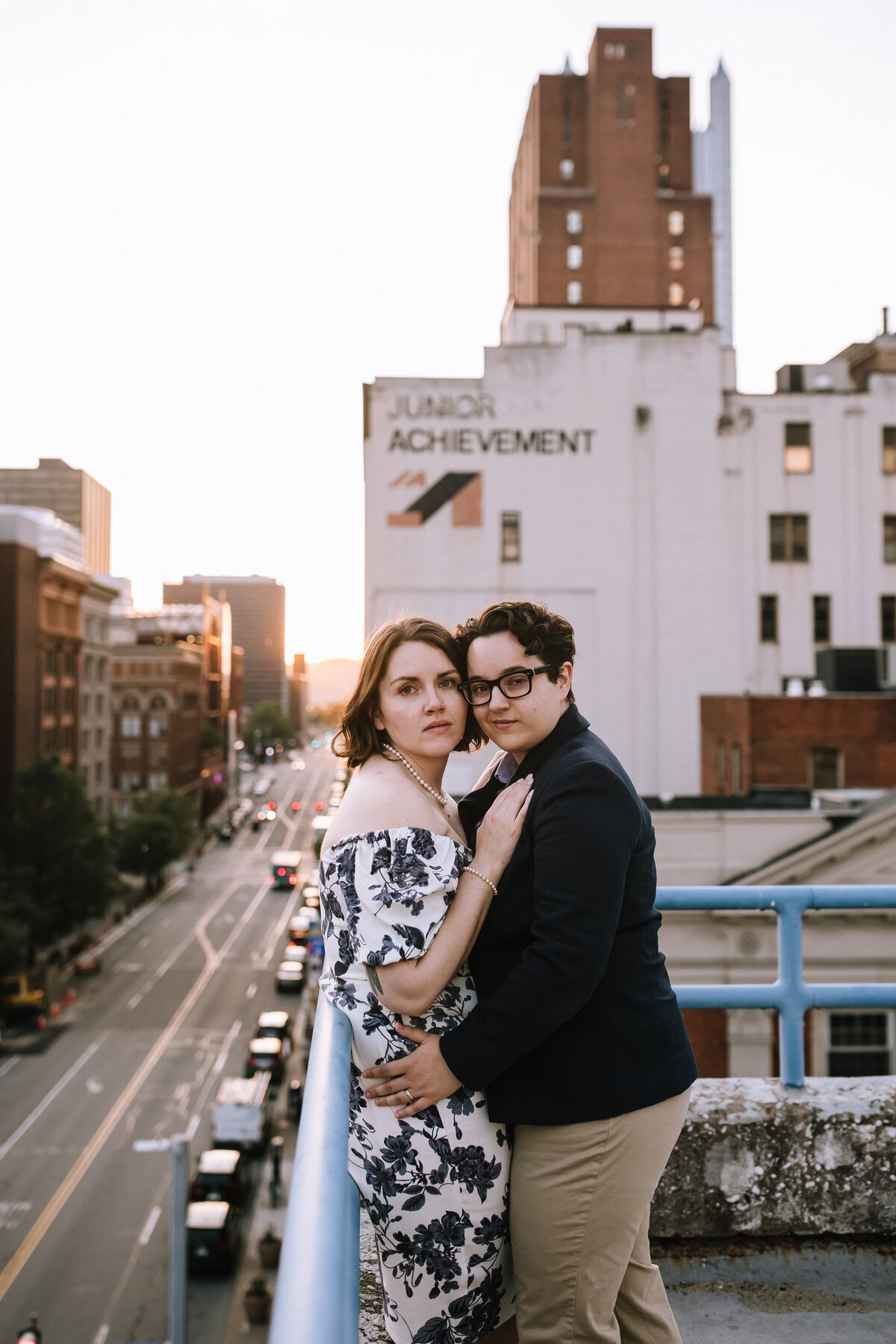 Engaged lesbian couple on a rooftop at sunset in downtown Pittsburgh.