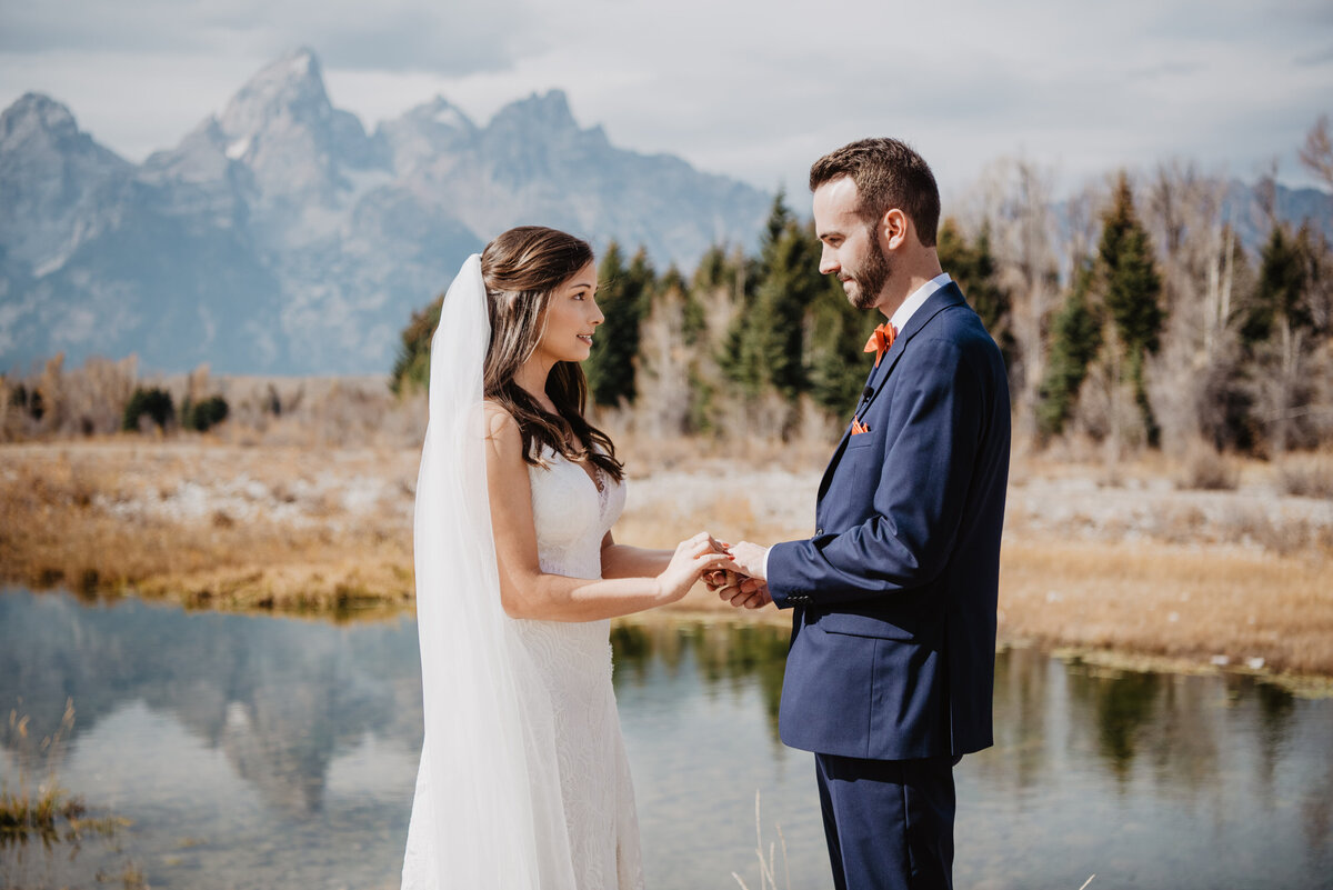 Photographers Jackson Hole capture bride placing ring on groom's finger