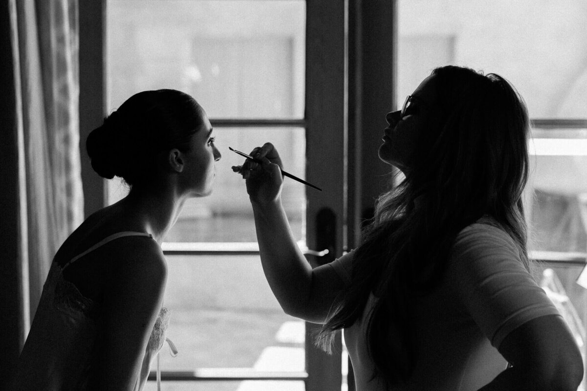 Bride getting her makeup done in soft morning light before the ceremony, captured by Scottsdale wedding photographers.