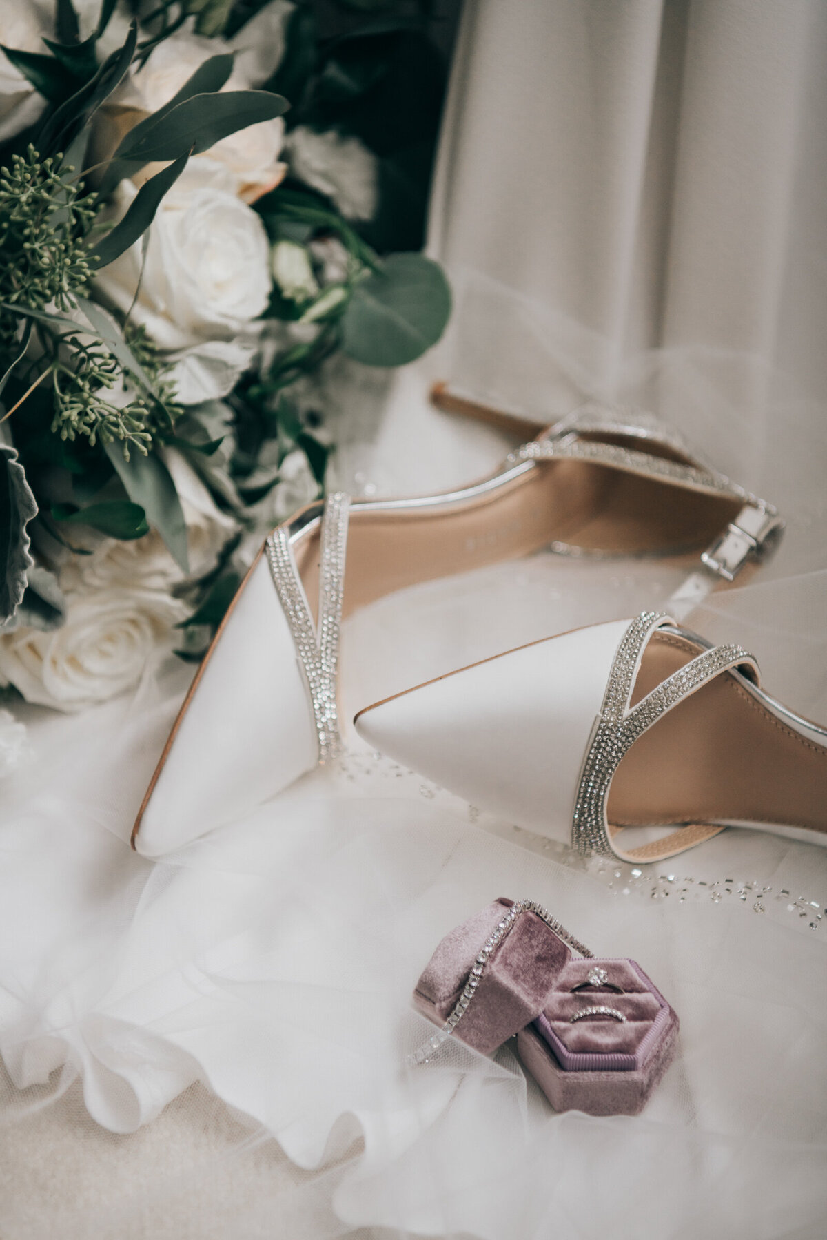 Elegant bridal details on the morning of the wedding days. Shoes, wedding rings, wedding invitation and bridal bouquet.