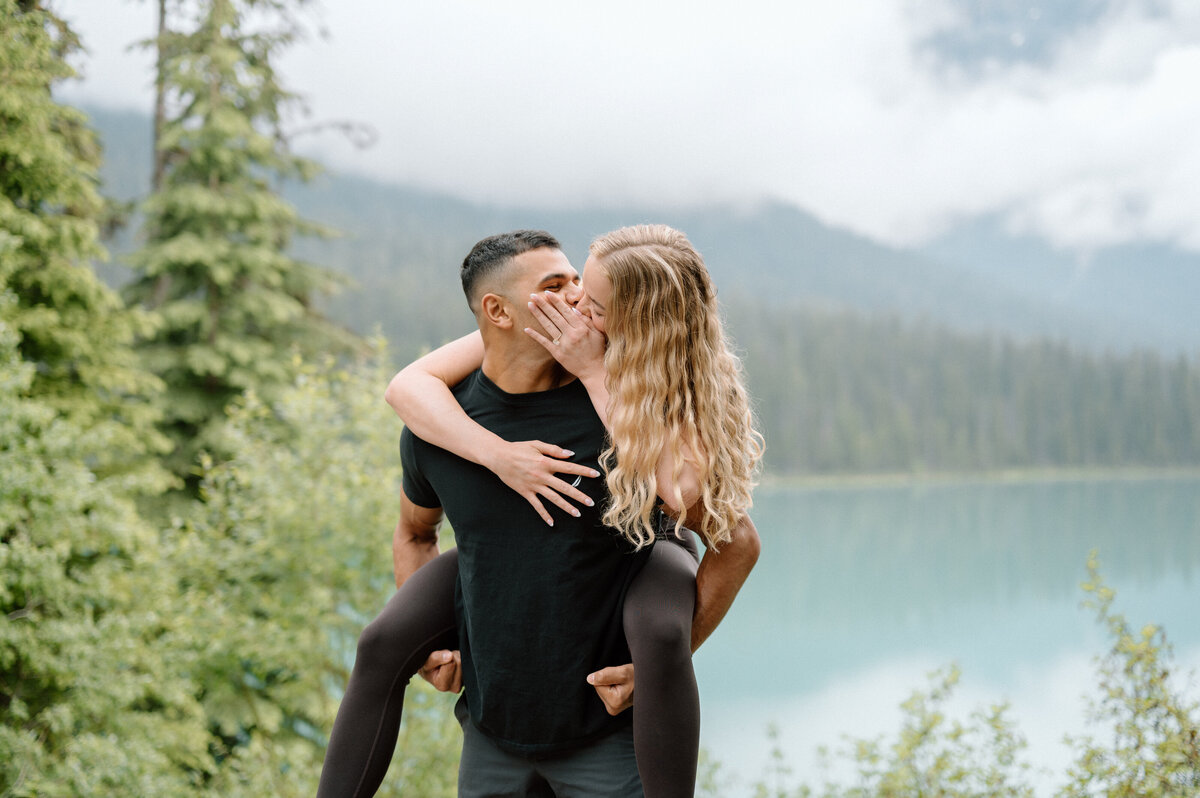 Man giving his fiancee a piggy back ride after proposing to her. 