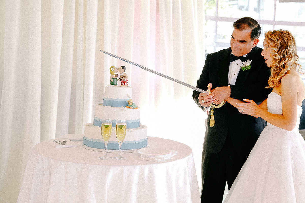 Funny wedding cake cutting using a big sword.