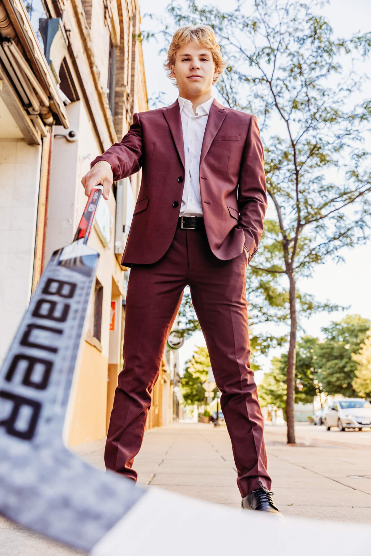 image of a high school boy from a ground view as he puts his stick out towards the camera and stares down