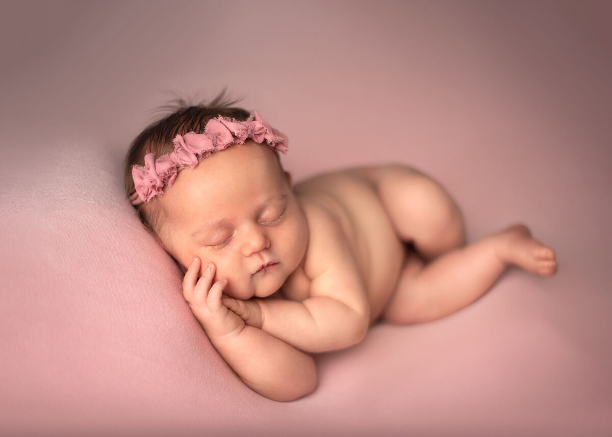 newborn sleeping on pink