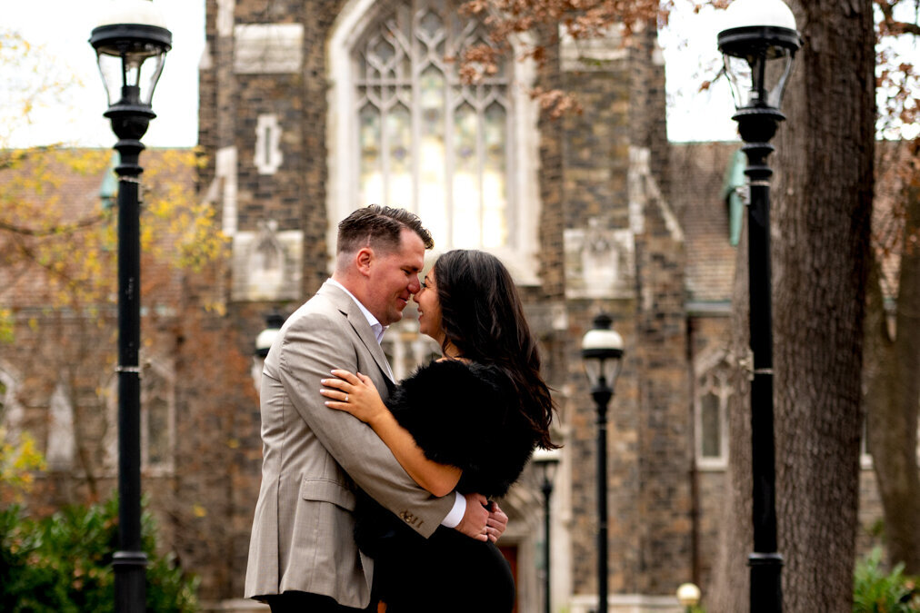 A couple embraces in front of a church.