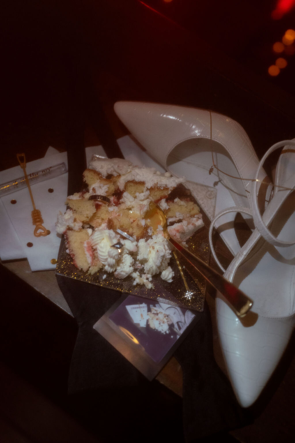Flat lay of a smashed wedding cake with white frosting, photographed by Lamblight Photography in Utah