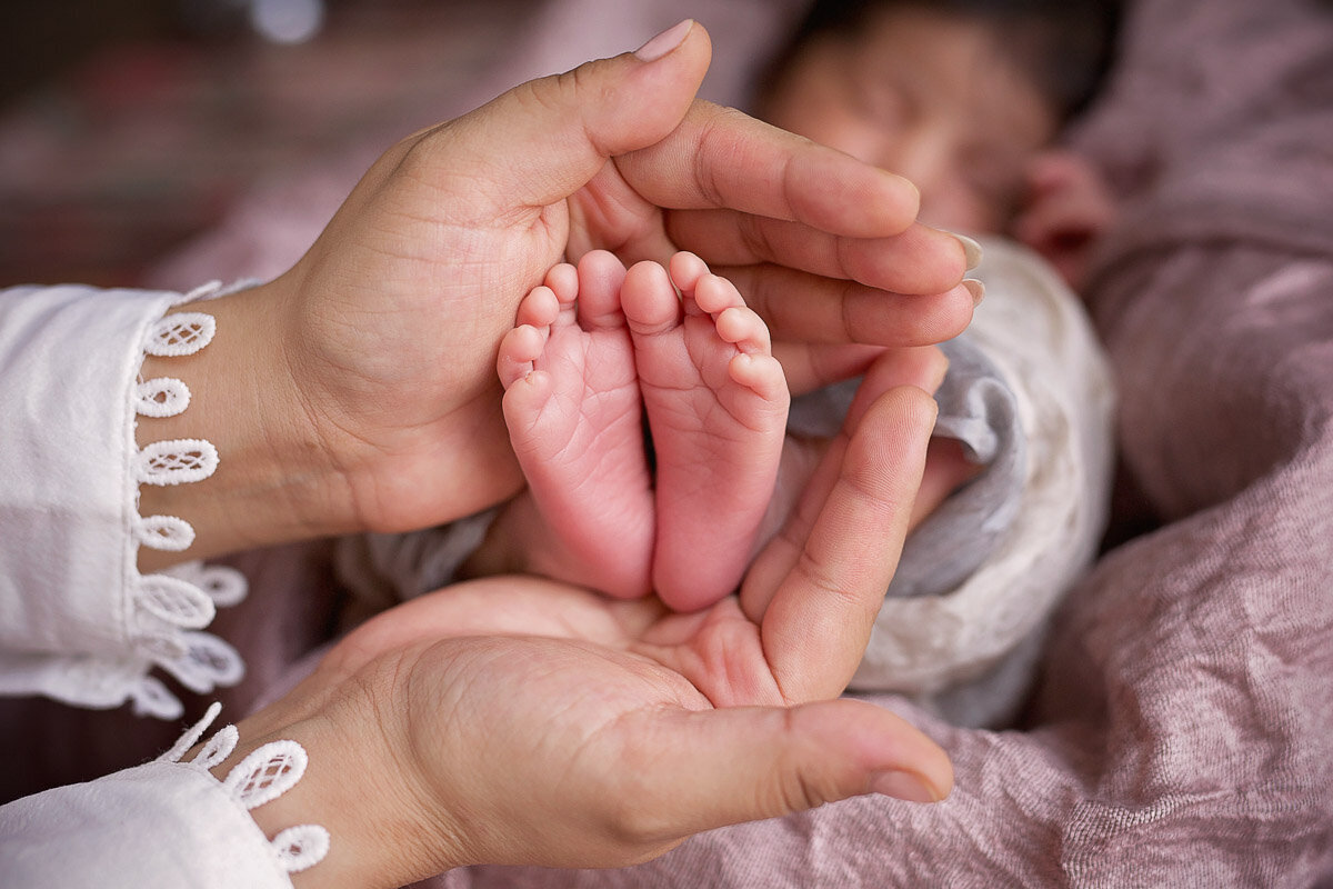 Newborn baby feet in mamas hand photo session at home in Calgary Alberta