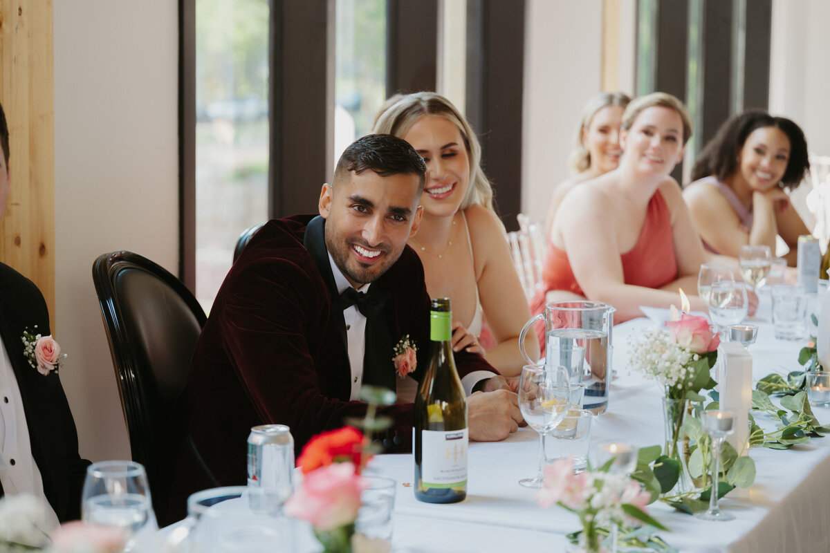 bride and groom enjoying reception speeches 