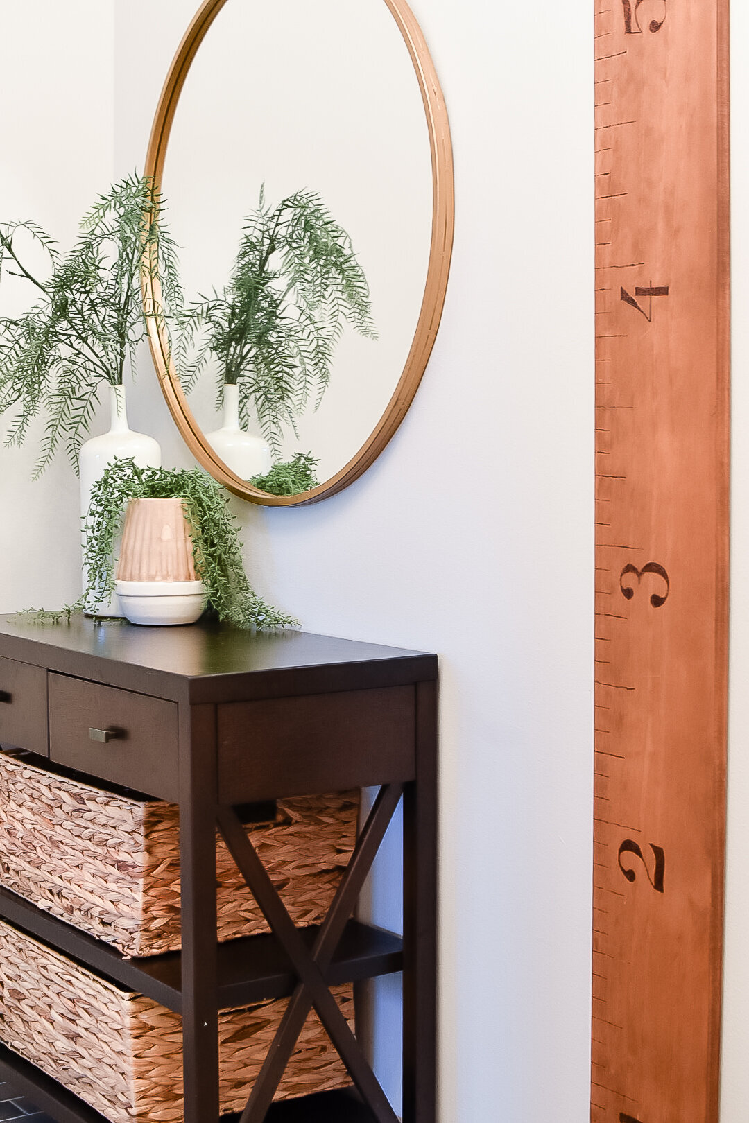 A large floor to ceiling wooden ruler hanging in an entryway