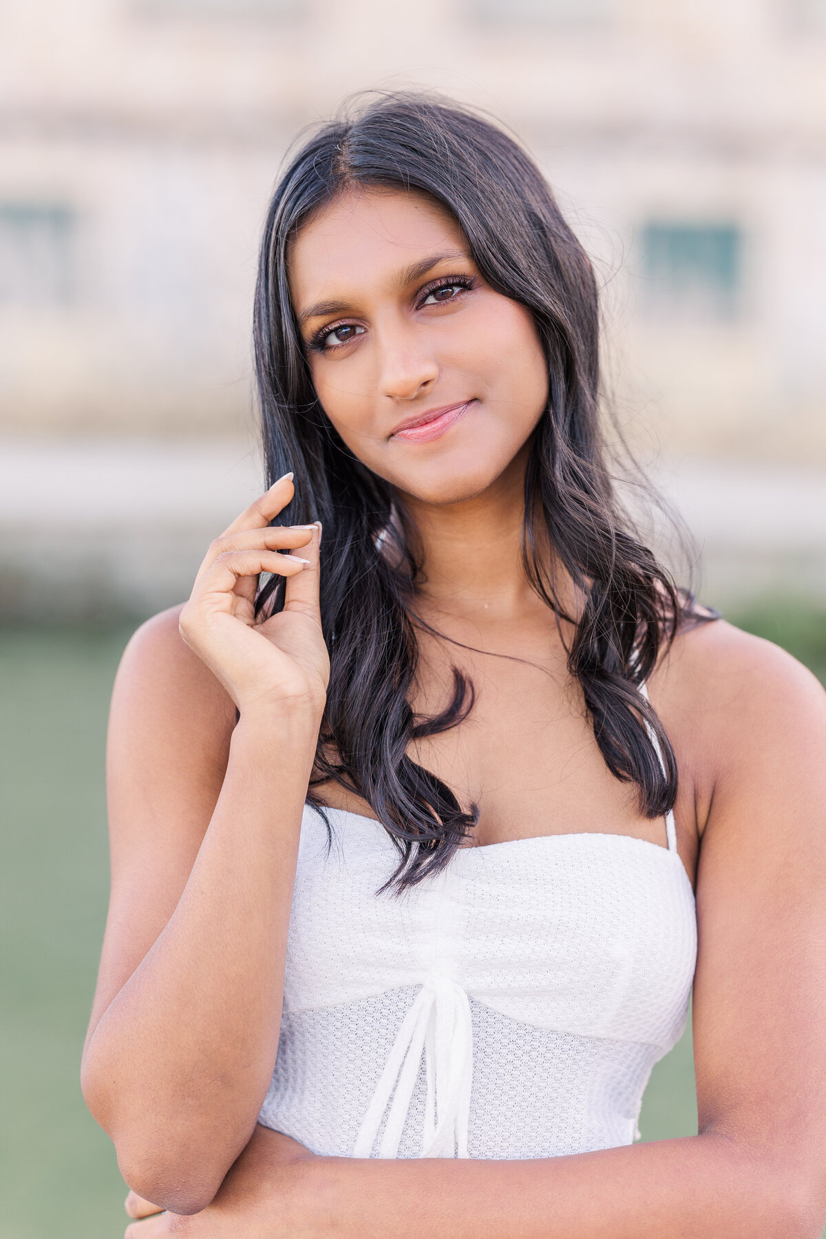 Close-up senior headshot of a young woman at Adriatica Village in McKinney, TX. Captured with a light and airy style by a DFW senior portrait photographer.