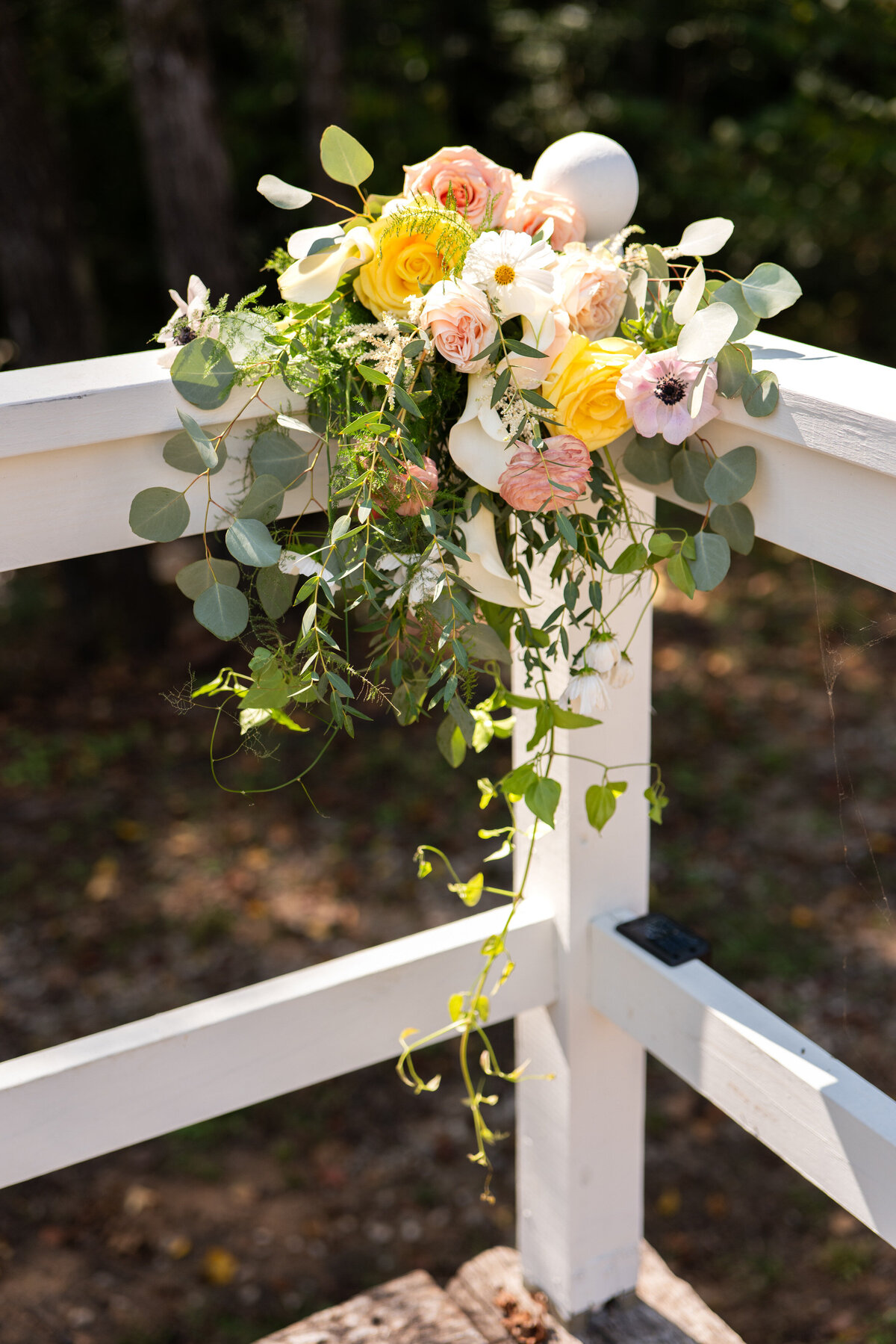 A small floral arrangement on the side of a railing 