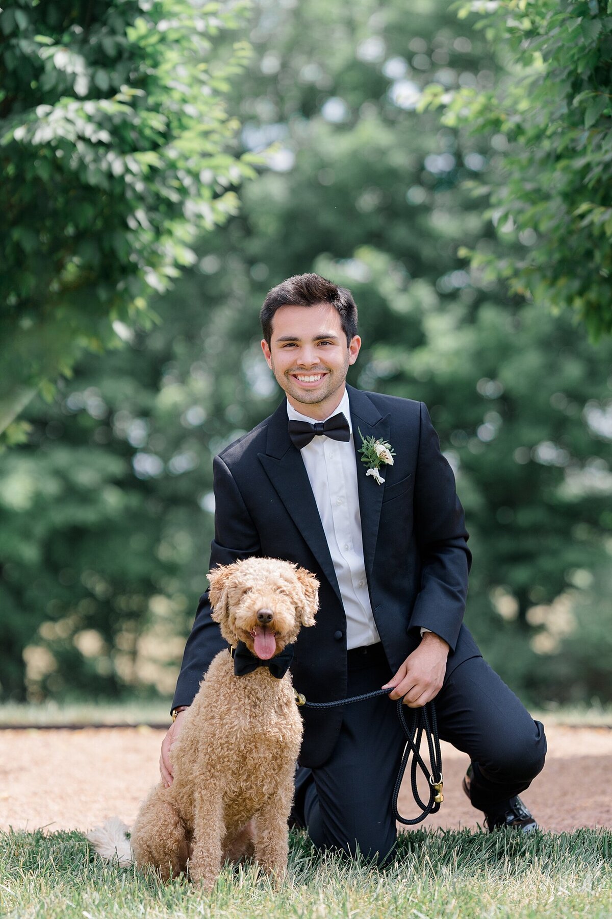 groom and his dog posing together on a lawn at Magnolia Hill wedding venue captured by Columbus wedding  photographer