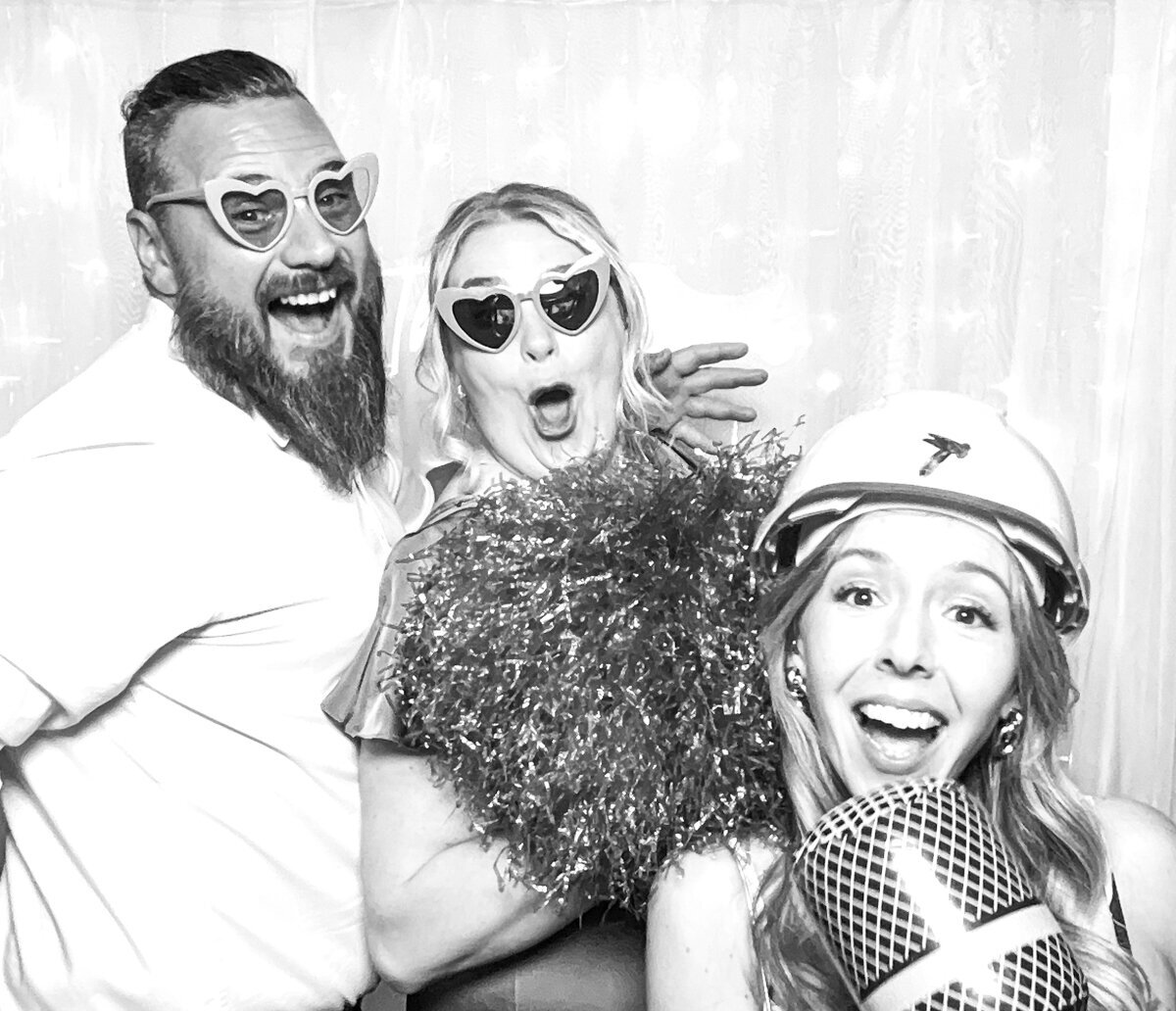 b&w image for a birthday party photo booth rental with guests having lots of fun using all the props 