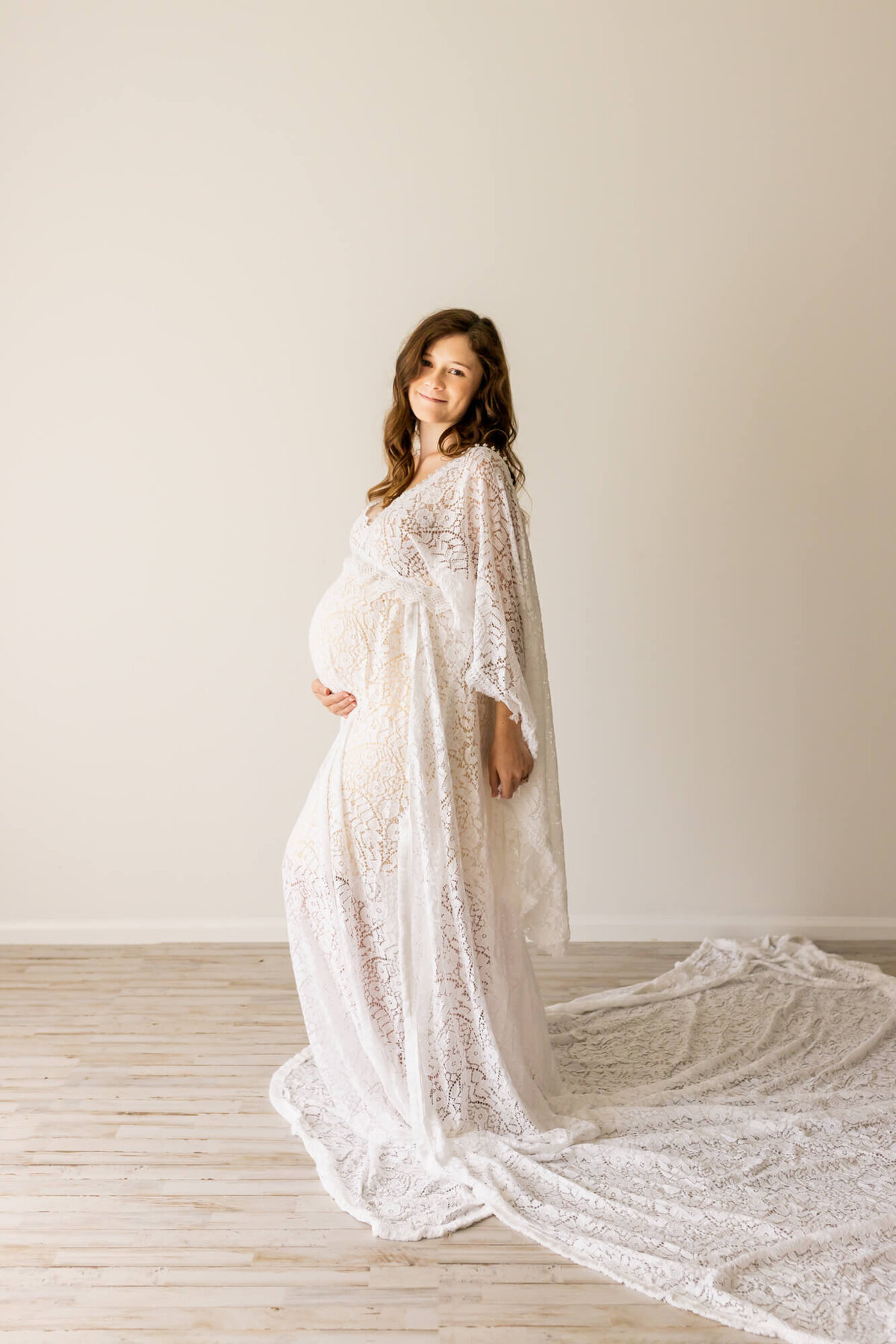 Mom to be in a white lace boho maternity dress
