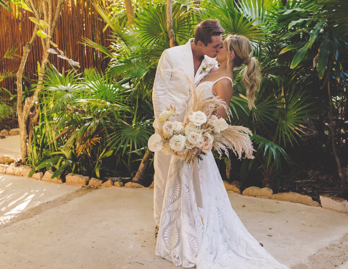 Bride and groom kissing on the paths at viceroy riviera maya wedding