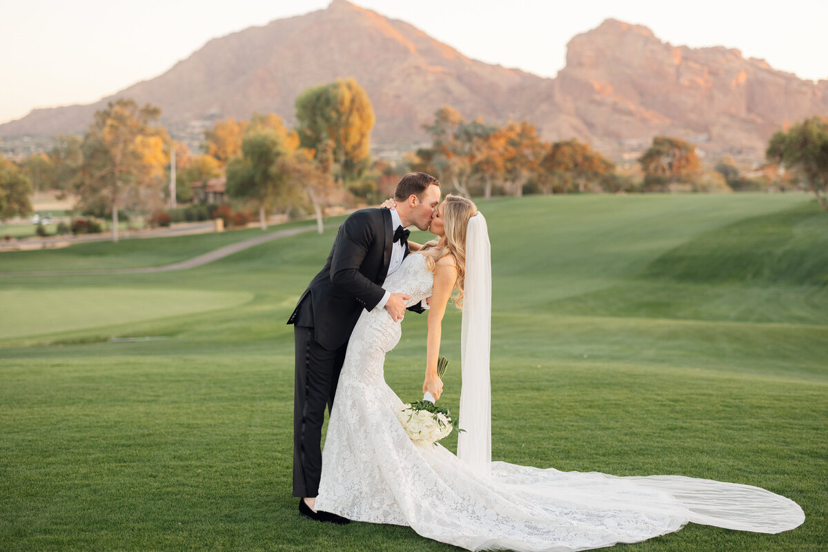 Bride and groom kissing for newlywed portrait with Camelback Mountain