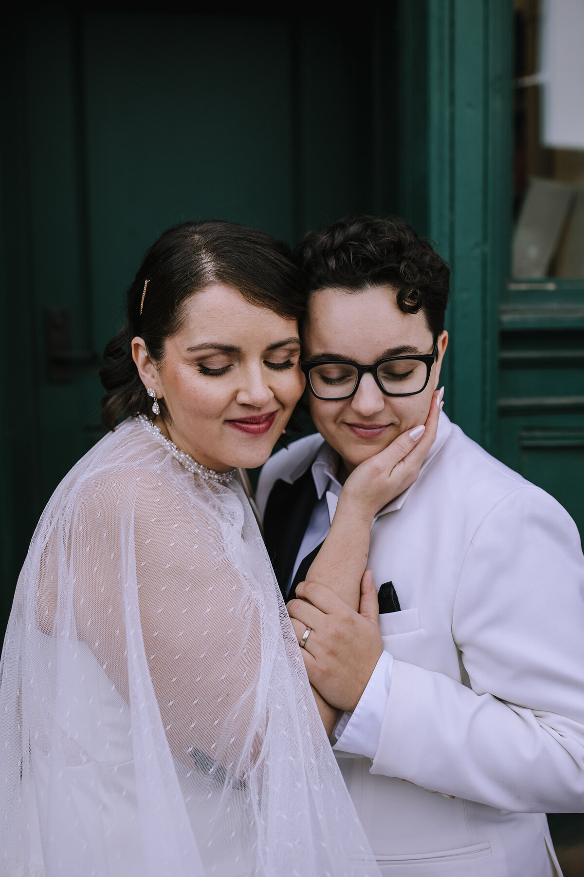 Lesbian couple cuddling on their wedding day outside of Heinz History Center. 