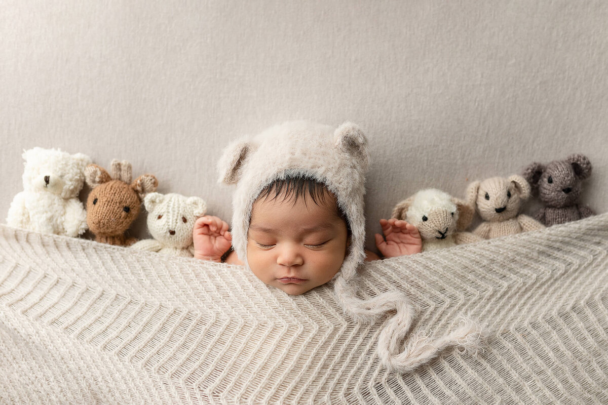 Baby boy posed with teddy bears.