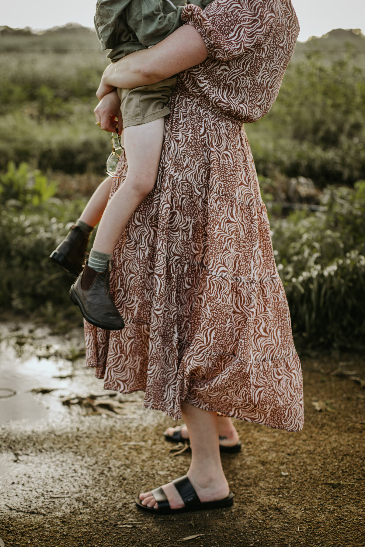 Close-up shot of mom holding her young child’s legs in her hands.