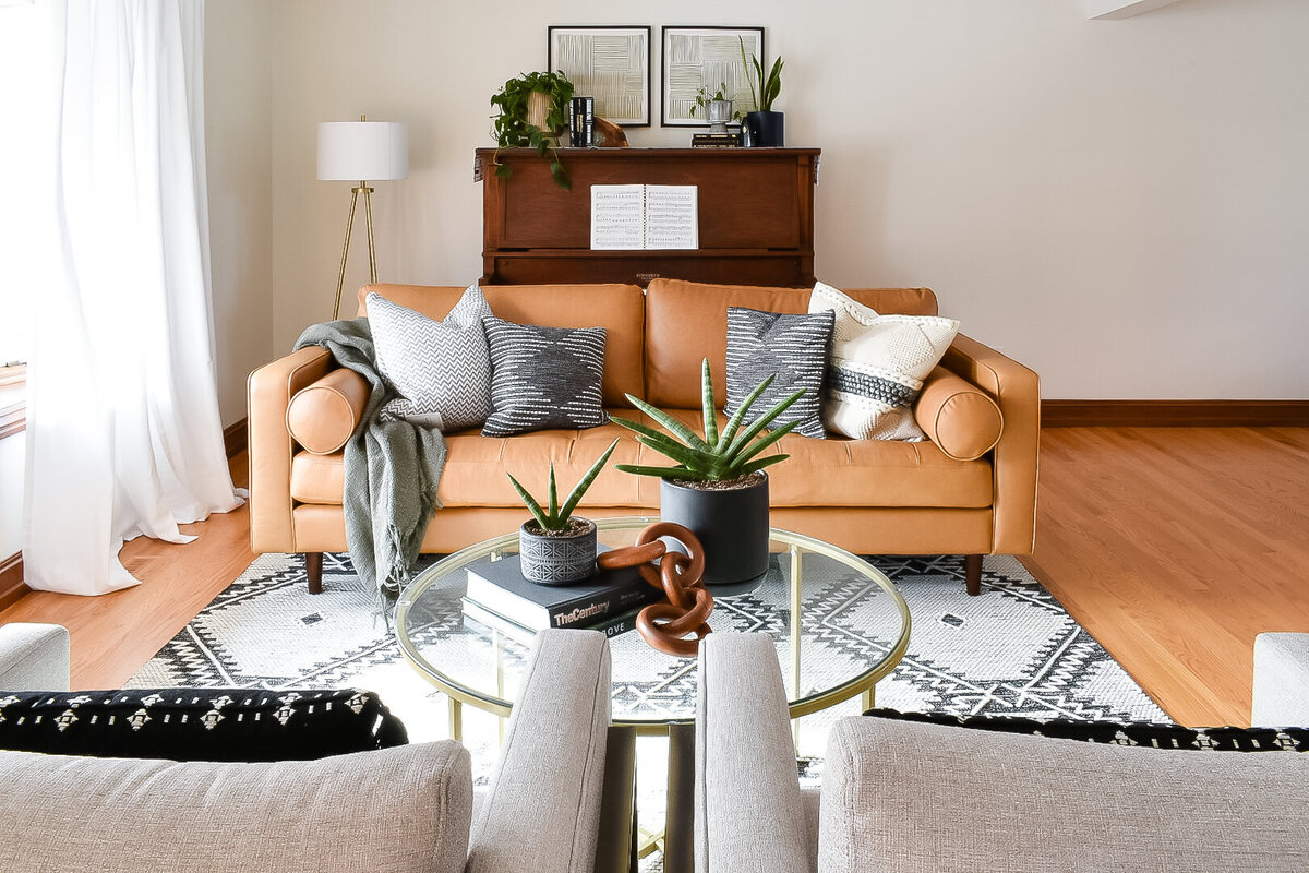 Two grey chairs face a brown leather living room couch