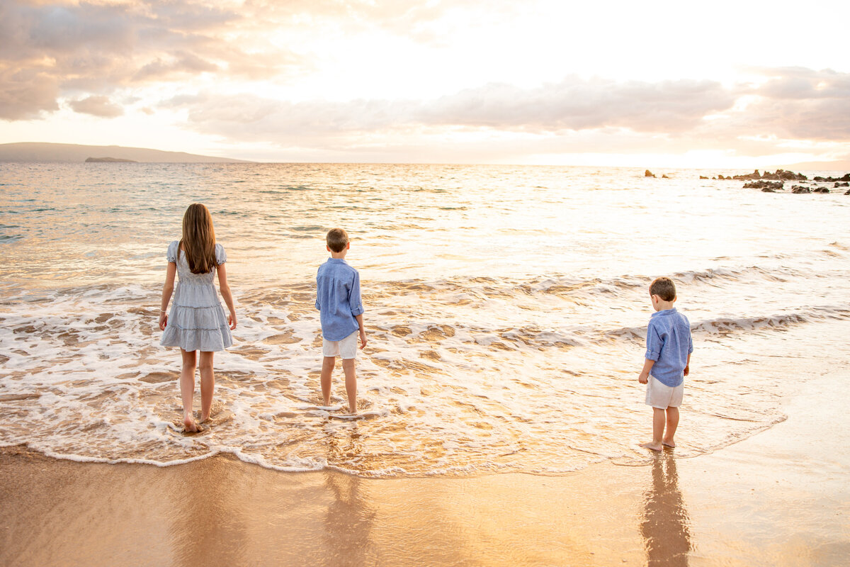 Maui Family Photographers capture children walking into water at sunset