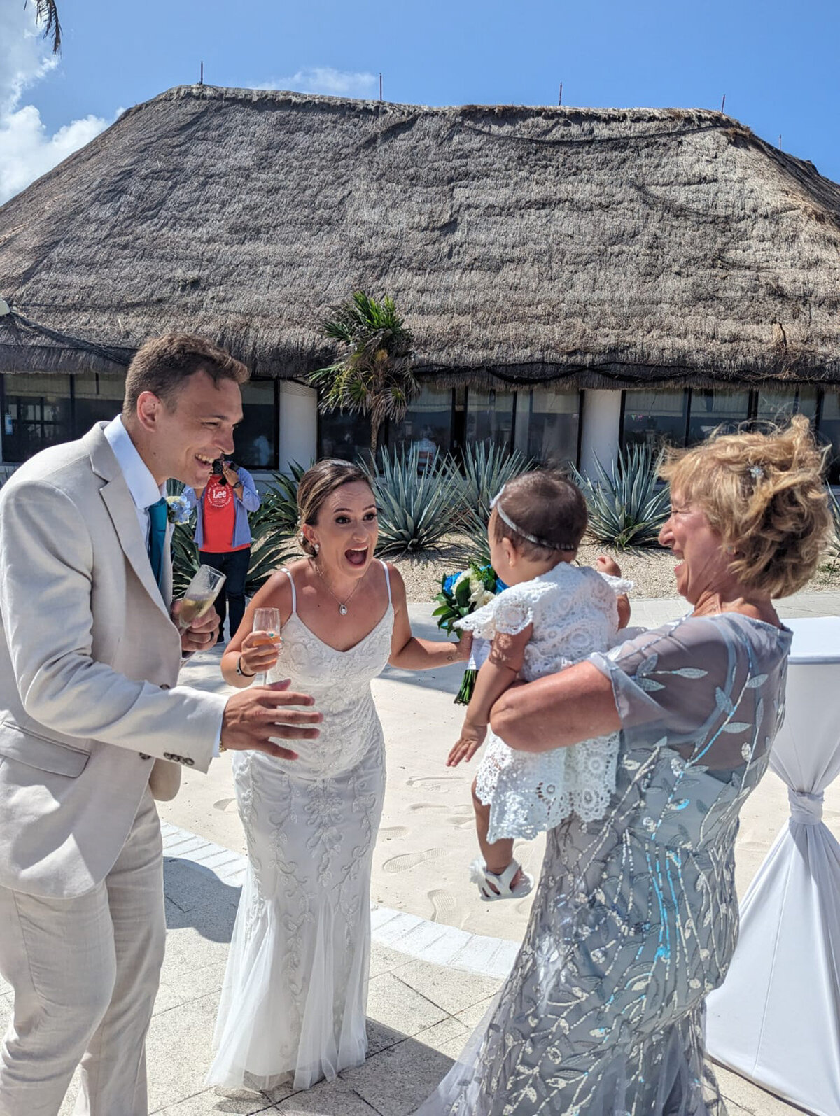 Bride and groom cheering a baby