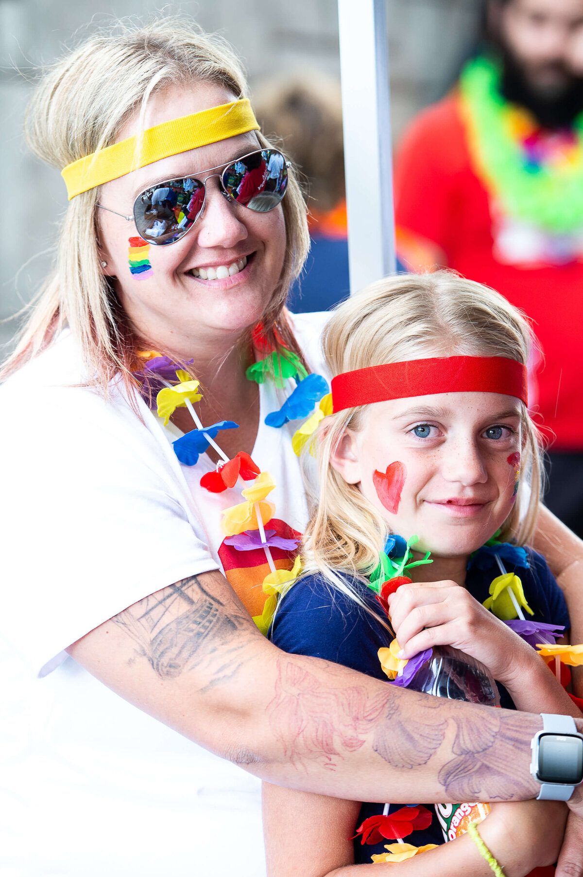 A mom and child dressed in pride colours waiting for the pride parade to start.  Captured by Ottawa Event Photographer JEMMAN Photography COMMERCIAL