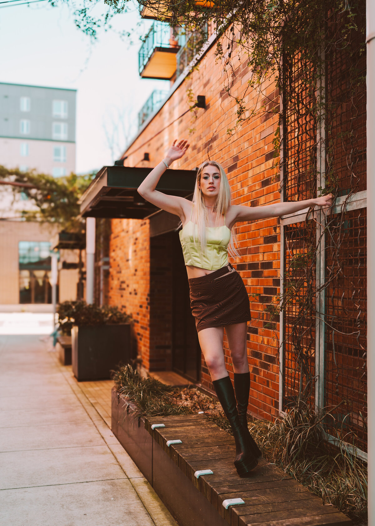 Woman walking confidently through a brick alleyway at golden hour – street fashion session by Mewphotovideo