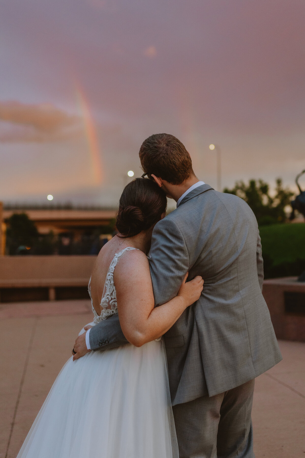 bride and groom look at rainbow